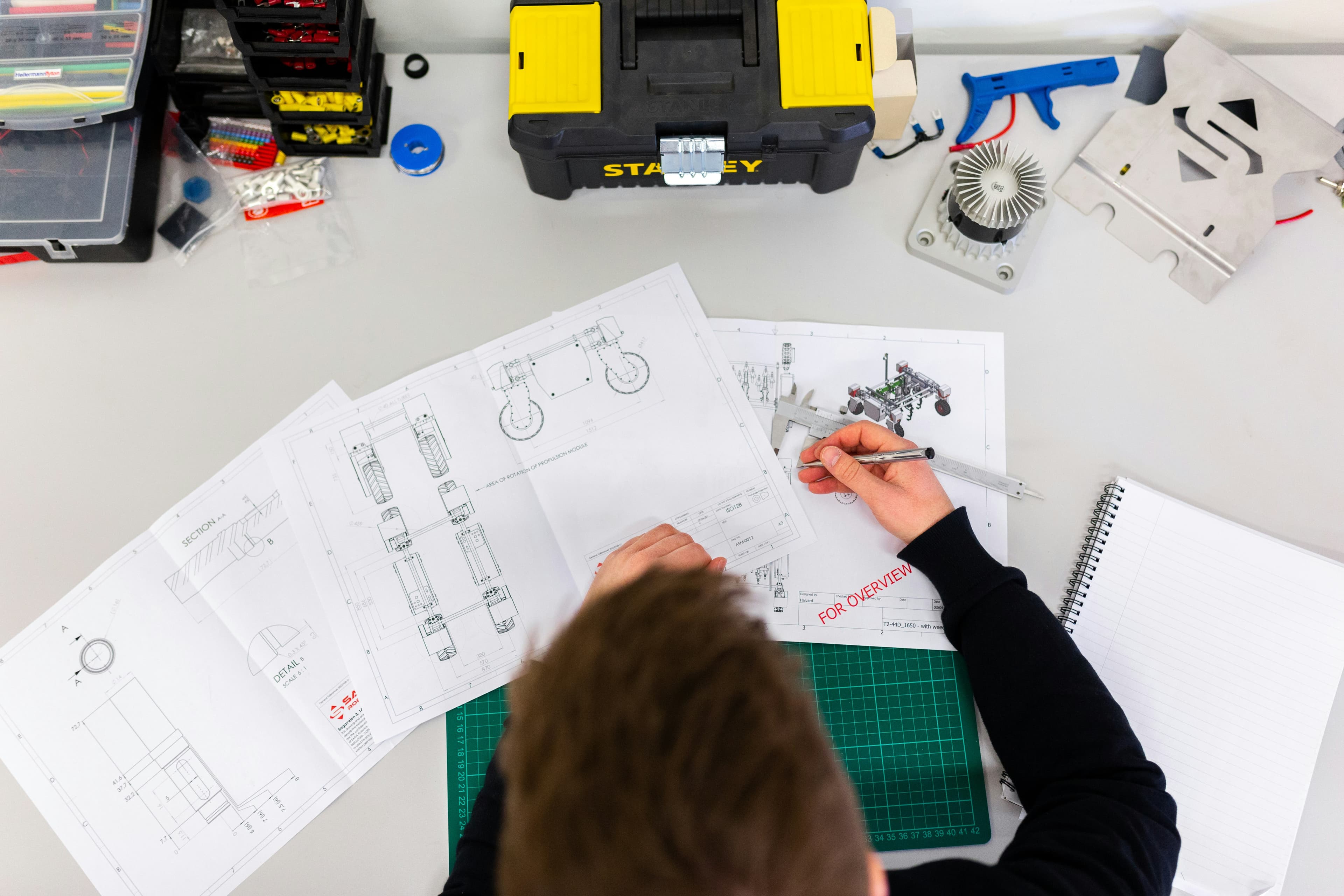 Technical drawings being marked up at a drawing desk